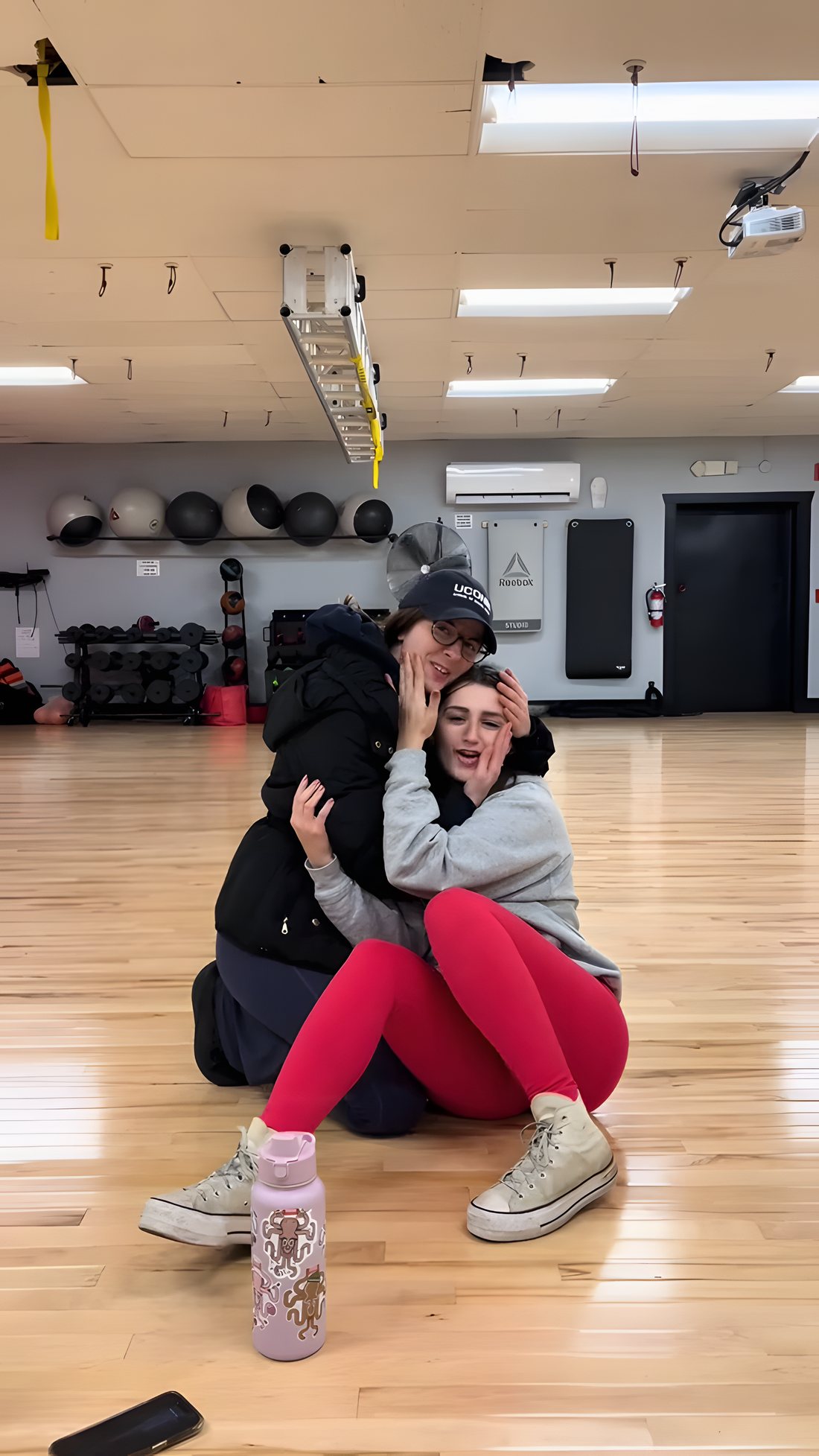 Two friends hugging and smiling in the SFF studio